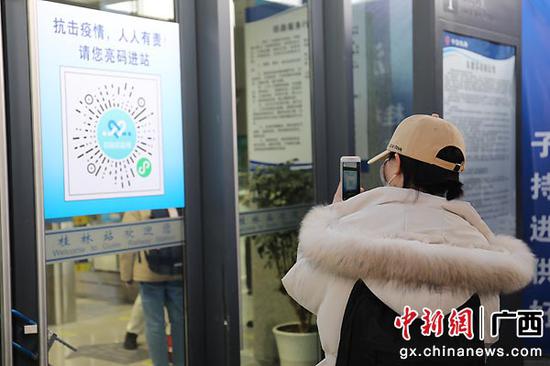 图为旅客使用手机进行健康码扫码。李倩 摄
