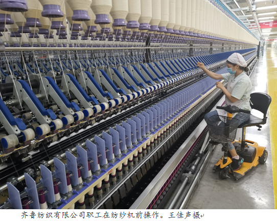 齐鲁纺织有限公司职工在纺纱机前操作。王佳声摄