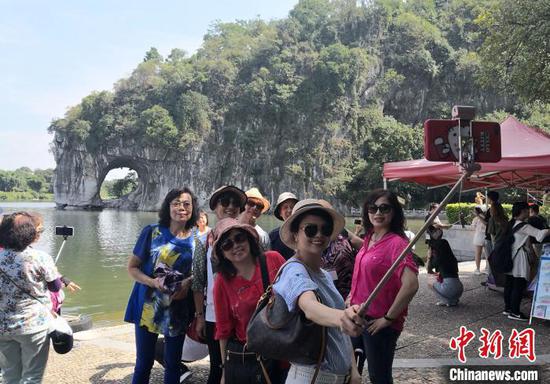 资料图：游客在桂林象山景区观光留影。唐梦宪　摄