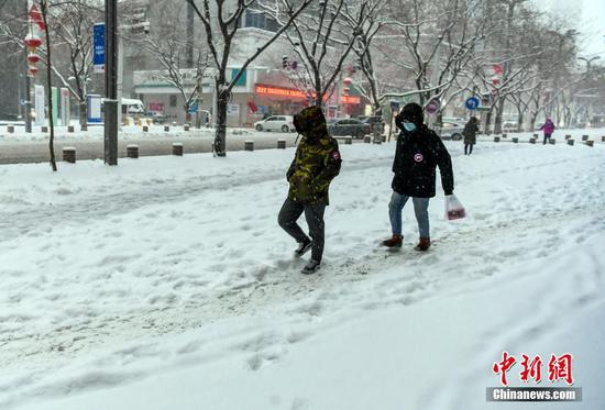 1月23日，新疆乌鲁木齐市迎来一场强降雪天气，民众冒雪外出。乌鲁木齐气象台1月23日10时41分发布暴雪黄色预警信号。 中新社记者 刘新