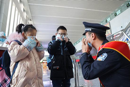 民警对候车旅客发放口罩，并叮嘱做好个人防护。