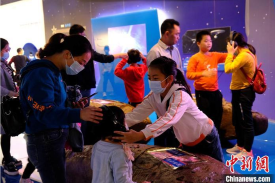 图为游客在“中国天眼”天文科普基地聆听“宇宙”的声音。田举　摄
