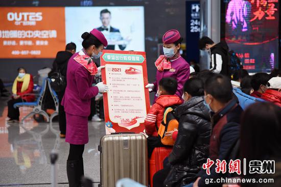 贵阳客运段青年志愿者在贵阳北站候车室为旅客介绍“春运出行防疫指南”。
