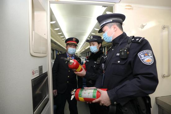 列车乘警、车长检查消防器械。韦士钊 摄