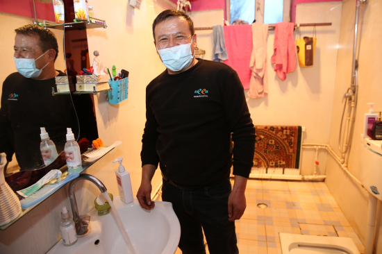 贫困户海拉提·吐依兰高兴地领记者看他家洗澡房。华岩明摄