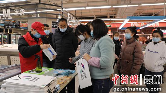 志愿者在永辉超市向市民发放疫情防控宣传资料 马秋霞摄