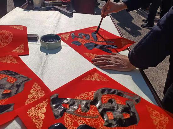 书法家现场为工人写“福”字。胡丁于 摄