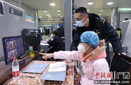 图为王海涛在进站口巡查旅客扫码及测体温进站情况。郑长贤 摄