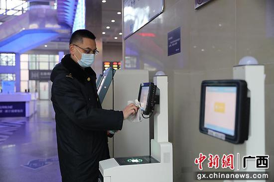 图为王海涛对自动售取票等旅客使用频率较高的设备进行擦拭消毒。郑长贤 摄