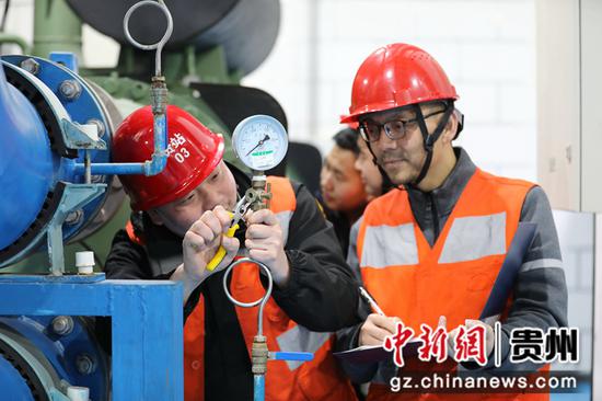 2021年2月7日，在贵阳北站空调机房内，车站设备管理维护人员正在检查空调压力设备状况。
