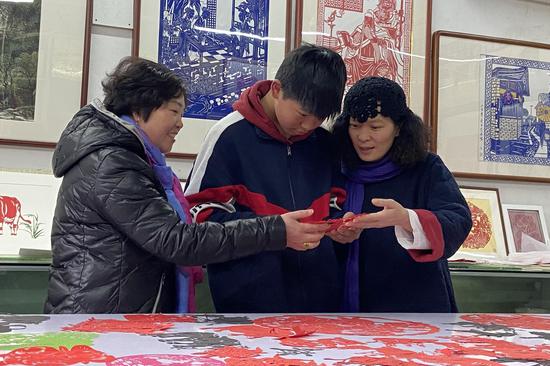 黄海仙在指导年轻人剪纸。徐晗昕（通讯员） 摄
