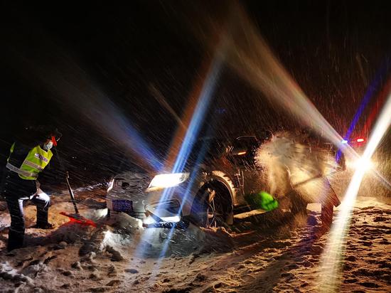 2月10日凌晨，民警们正在齐心协力用铲、推、挖的方式营救被困车辆。