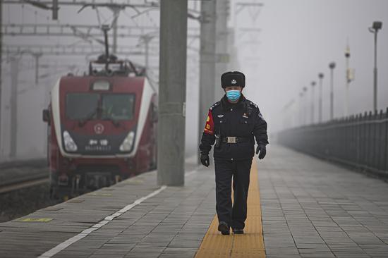 小站民警史建龙在大雾中对达坂城车站进行安全巡查。