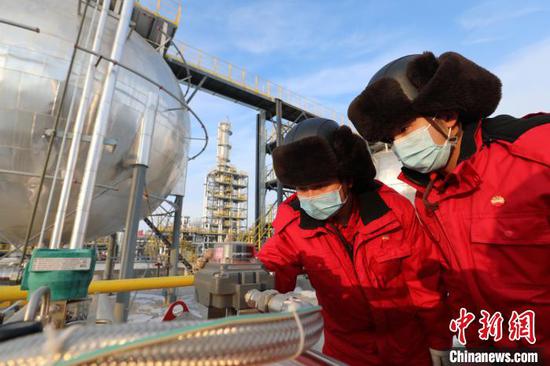 新疆油田采气一厂克拉美丽气田两名技术干部正在现场查看自动化运行情况。　王涛 摄