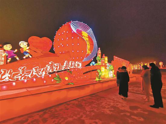 2月18日晚，游客在博乐市赏花灯，拍照留念。秦桂莲 摄