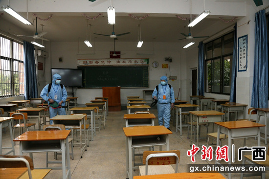 图为：消杀公司工作人员在对学校教室进行消杀 潘志安 摄