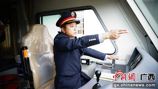 图为玉林工务段综合运输车间指导司机谢进宏在驾驶轨道车中进行眼看手比口呼标准作业。谭育俊  摄