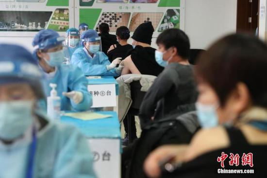 资料图：1月8日，在北京市海淀区学院路街道临时接种点内，医护人员为接种者注射疫苗。 中新社记者 蒋启
