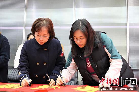 女职工在廉洁标语横幅上签名。中建三局一公司广西分公司供图