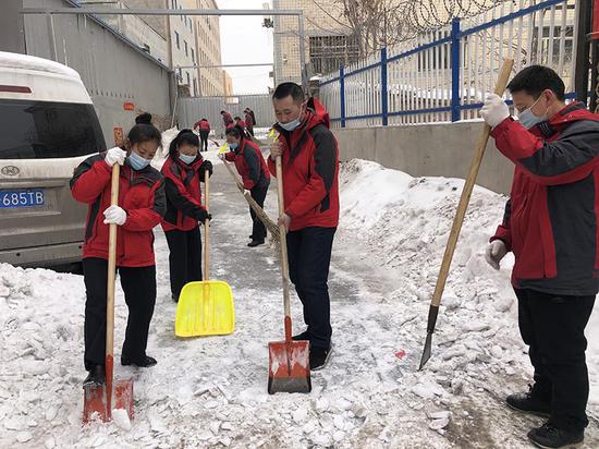 志愿者对辖区道路积冰处进行除冰。