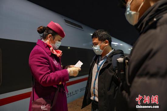 图为3月7日晚，列车长杨露在核对旅客信息。 瞿宏伦 摄