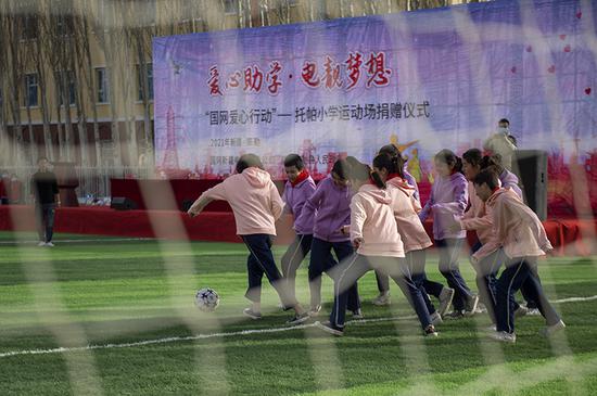 托帕小学的两支女生足球队在新足球场上比赛。（周广科 摄）