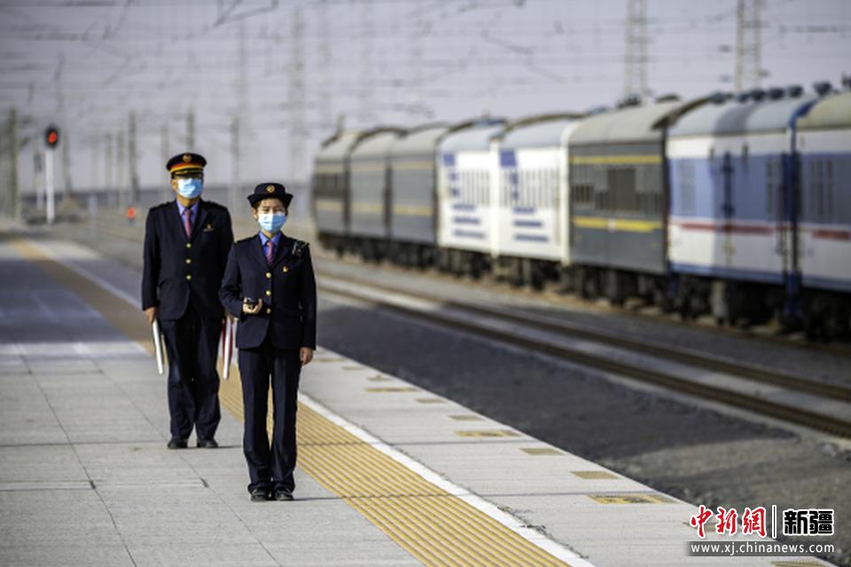 　　3月8日，在新疆巴音郭楞蒙古自治州格库铁路尉犁站，客运值班员正在火车站台接发列车。李飞 摄