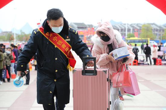 桂林火车站志愿者为旅客提行李。刘锦涛 摄