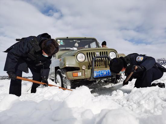3月7日，民警正在清理被困车辆底部积雪