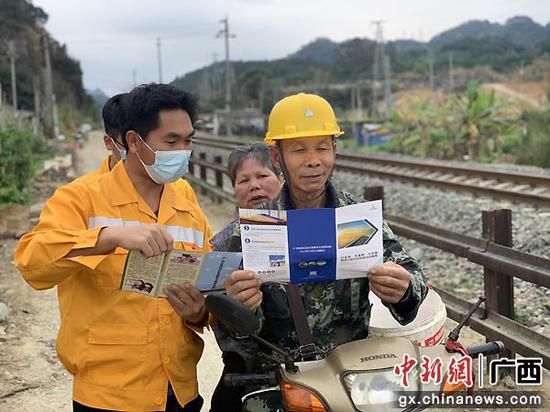 在凭祥市湘桂线沿线，铁路志愿者给附近居民讲解铁路安全知识，倡导文明出行。谢永洲  摄