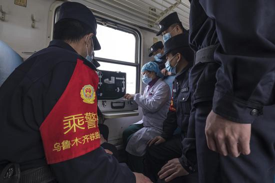 医生利用列车急救箱向乘警讲解各种医药物品的种类和使用方法。
