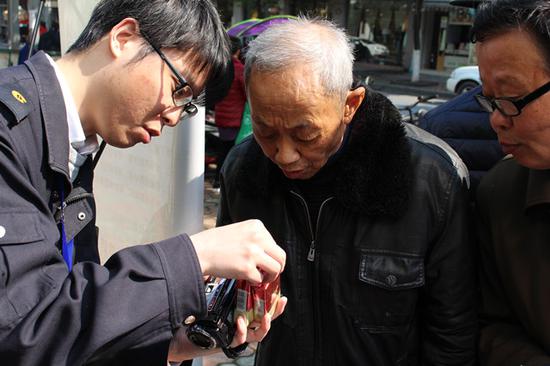 杭州市烟草专卖局执法人员为群众讲解真假烟鉴别知识。杭州市烟草专卖局 供图