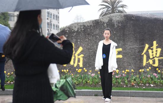 一位考生在浙江传媒学院门口拍照。王刚 摄