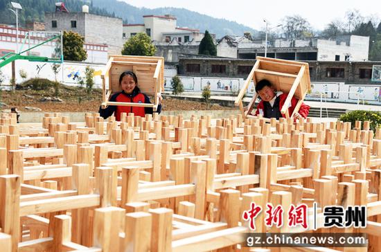 2012年3月15日，贵州省毕节市黔西县铁石小学的孩子们兴高采烈地将新课桌椅搬进教室。 熊军万 摄
