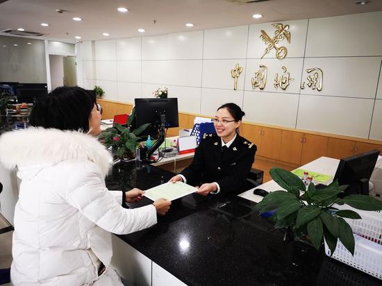 金华海关原产地签证人员在给某企业签发一份中韩自贸协定原产地证书。罗奕 供图