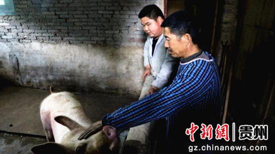 刘琴刚（右）在农户刘秋祥家中交代喂猪注意事项