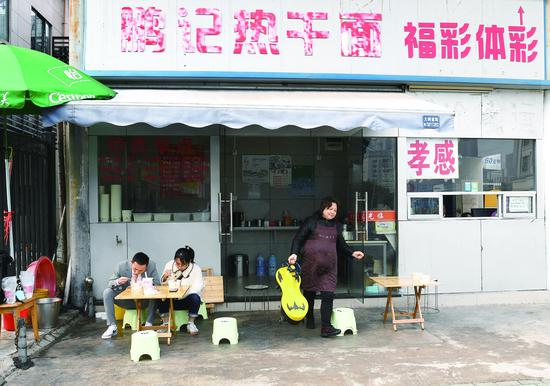 3月20日，李梦鸽与张敏走出火车站后，做的第一件事就是吃热干面。这是张敏第一次品尝热干面。闵勇 摄