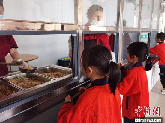 图为荔波县第五小学的学生在食堂打吃营养午餐。　周燕玲 摄