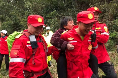 救援队队员背着老人下山  林东 摄