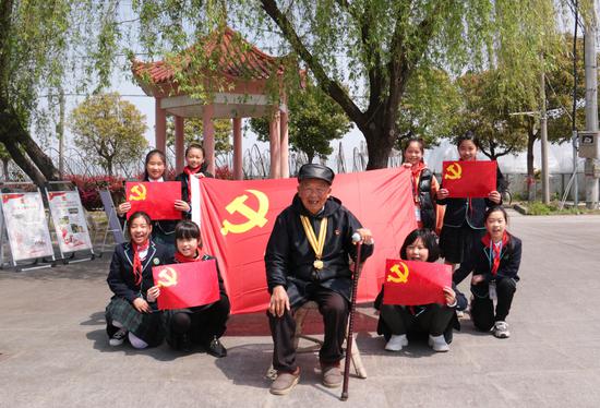 少先队员和抗战老兵合影留念。李丹 摄
