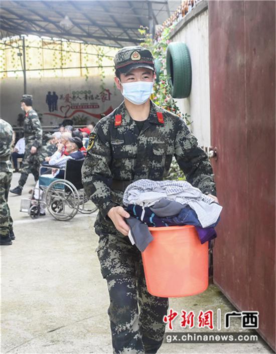 武警官兵为老人清洗衣物。