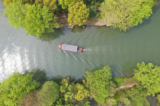 一艘游船从西溪湿地河道间驶过（无人机照片）。王刚 摄