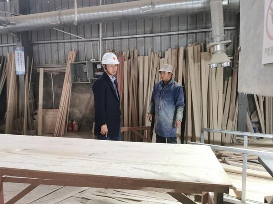 工作人员督促木材厂进行问题整改。许旭 摄