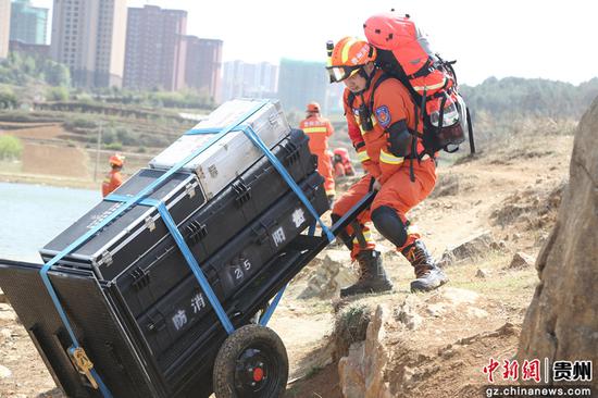 图为贵阳消防救援支队消防员徒步搬运救援设备。郑政 摄