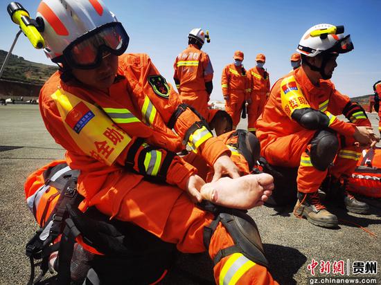 图为毕节消防救援支队消防员向记者展示磨掉皮的脚。陈曦 摄