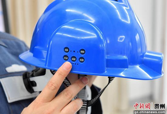 贵阳市供电局万松变电站工作人员在介绍智能安全帽WIPI传输的功能按健。