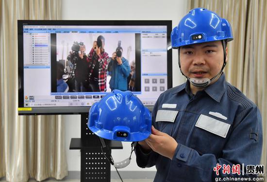 贵阳市供电局万松变电站工作人员在介绍智能安全帽WIPI传输的功能。