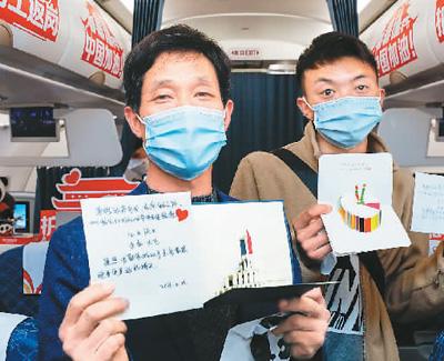  2月23日，在成都开往广州的川籍农民工返岗专机上，当天过生日的乘客展示生日贺卡等礼物。新华社记者 沈伯韩摄