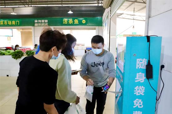 市民领取生物降解环保袋免费发放机。翁哲宁 摄