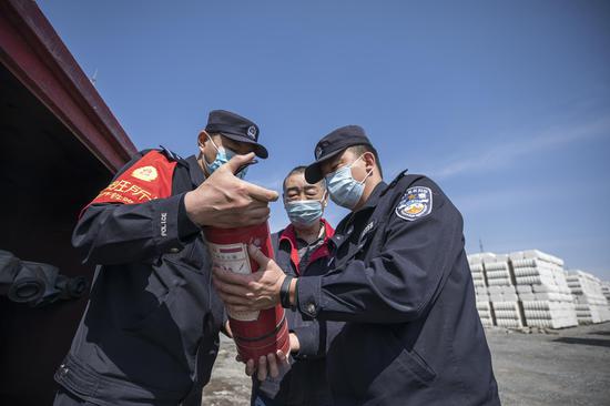 民警对货场棉花存放地的消防器材进行安全检查。